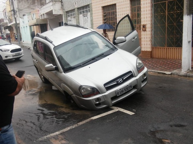Buraco engole carro na Rua Melchior Dias, centro de Jacobina