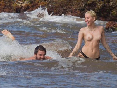 De topless, Miley Cyrus curte praia com Patrick Schwarzenegger