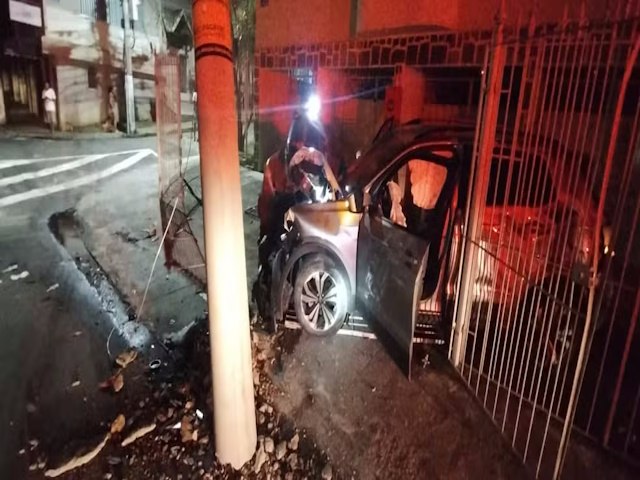 Carro fica destrudo aps bater em poste e grade de garagem no Centro de Juiz de Fora